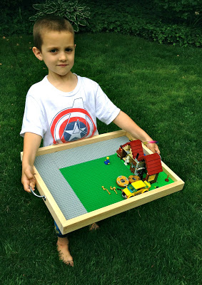 little boy holding lego tray