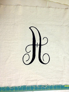 fabric letter pinned onto drop cloth