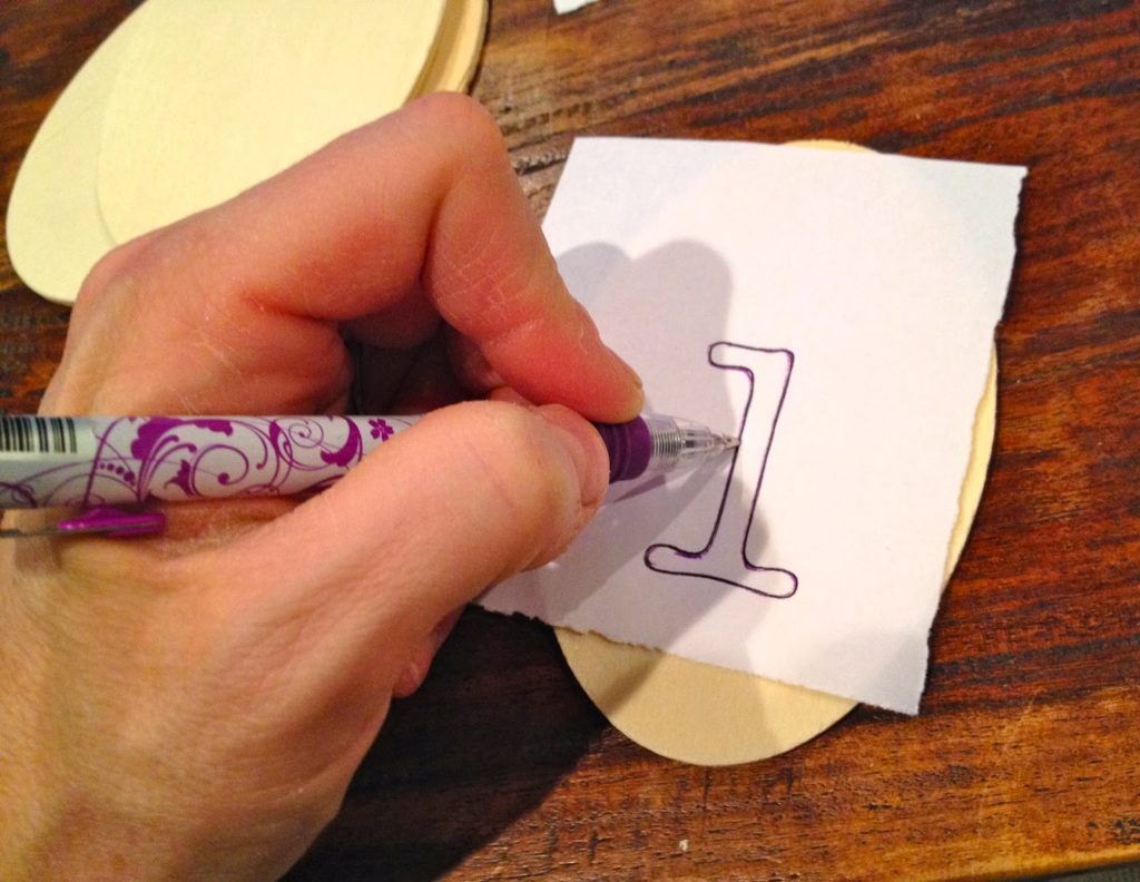 tracing number onto wood tag with pen
