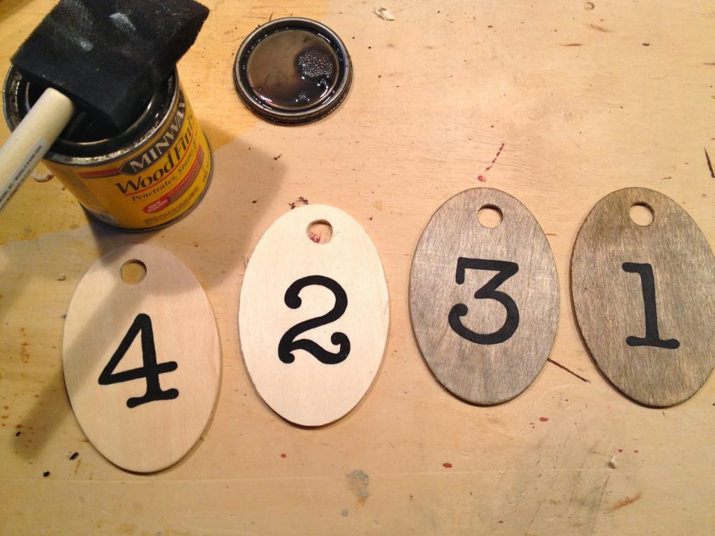 applying stain to wood tags over acrylic paint