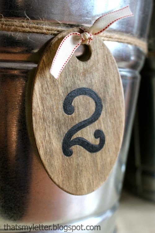 stained oval wood tag with handpainted number detail