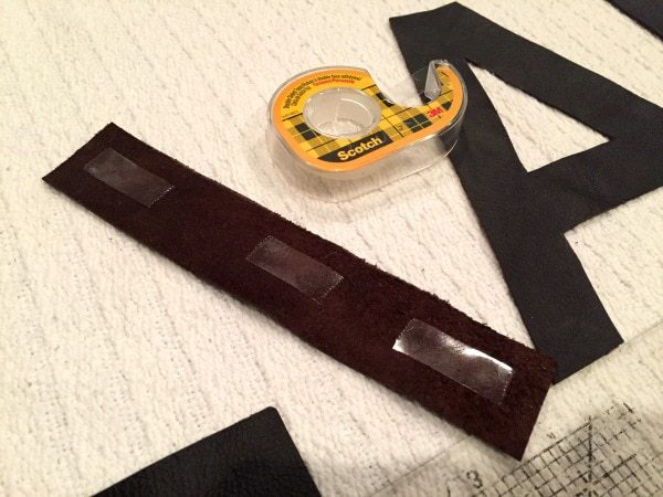taping leather letters to blanket pillow
