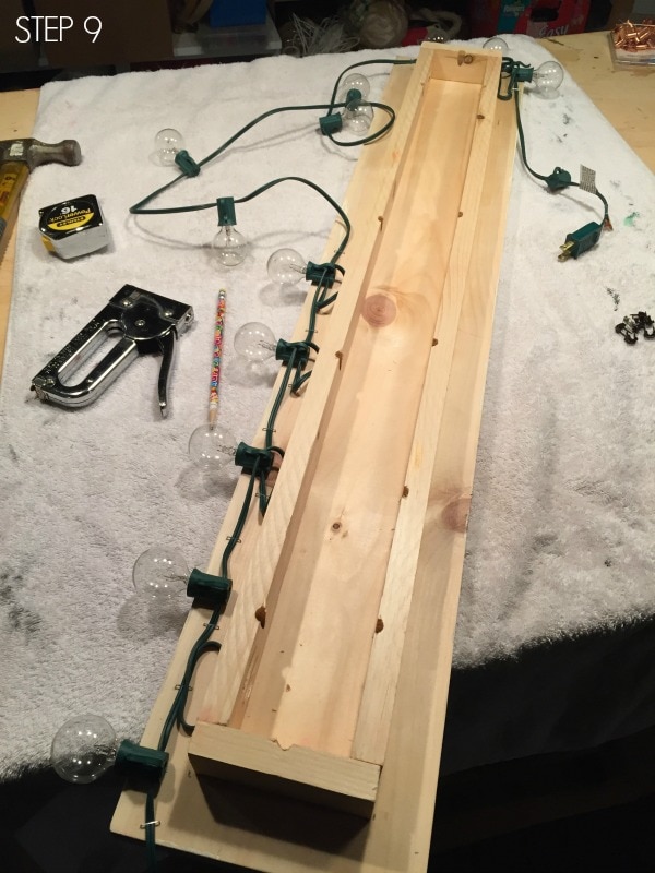 staple string lights onto wood board