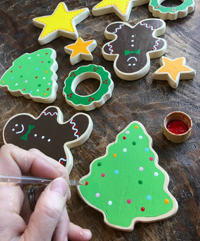 painting details on wood cut out cookies